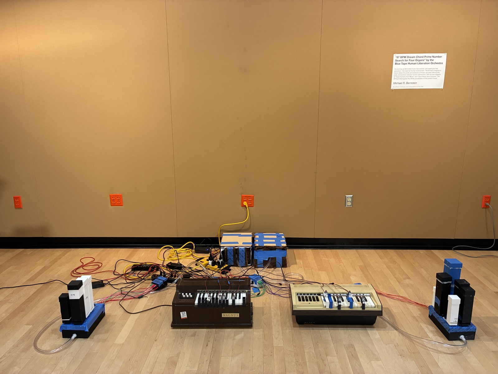 Four toy organs and modified hardware on the floor of the installation space